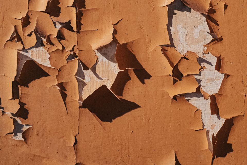 Paint peeling off a wall after long-term moisture